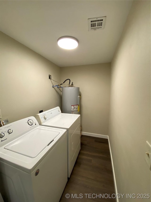 washroom featuring independent washer and dryer, electric water heater, and dark wood-type flooring