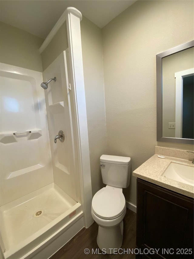 bathroom with vanity, toilet, wood-type flooring, and walk in shower