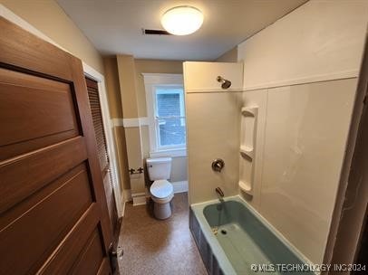 bathroom with toilet and bathing tub / shower combination