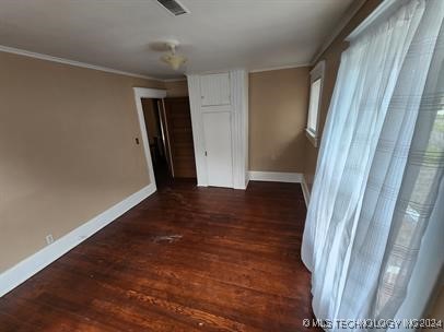 interior space featuring dark hardwood / wood-style floors and ornamental molding