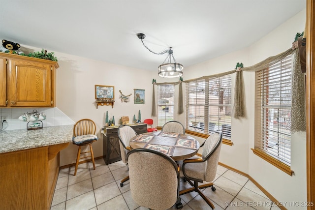 dining space featuring baseboards, a healthy amount of sunlight, and light tile patterned flooring