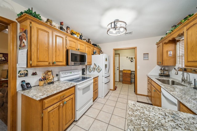 kitchen with white appliances, visible vents, light tile patterned flooring, a sink, and decorative backsplash