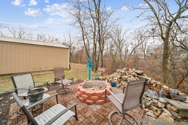 view of patio / terrace featuring an outbuilding and an outdoor fire pit