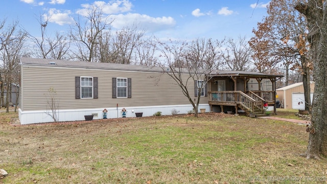 back of property featuring an outbuilding, covered porch, and a lawn