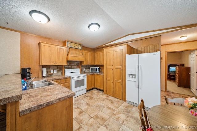 kitchen with light countertops, custom range hood, vaulted ceiling, white appliances, and a sink