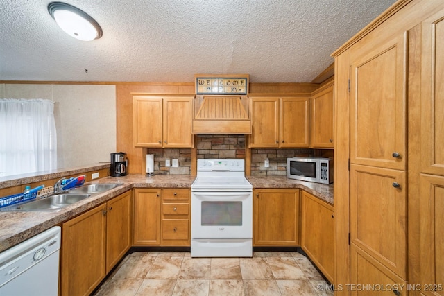 kitchen featuring a sink, white appliances, custom exhaust hood, and a textured ceiling