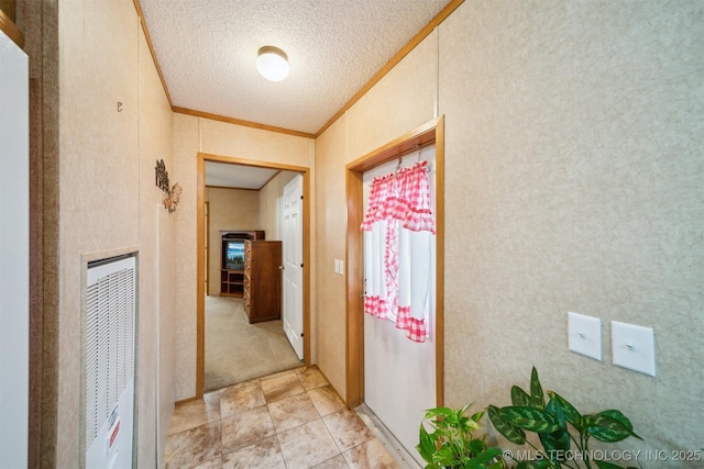 hall featuring a textured ceiling, ornamental molding, and a heating unit