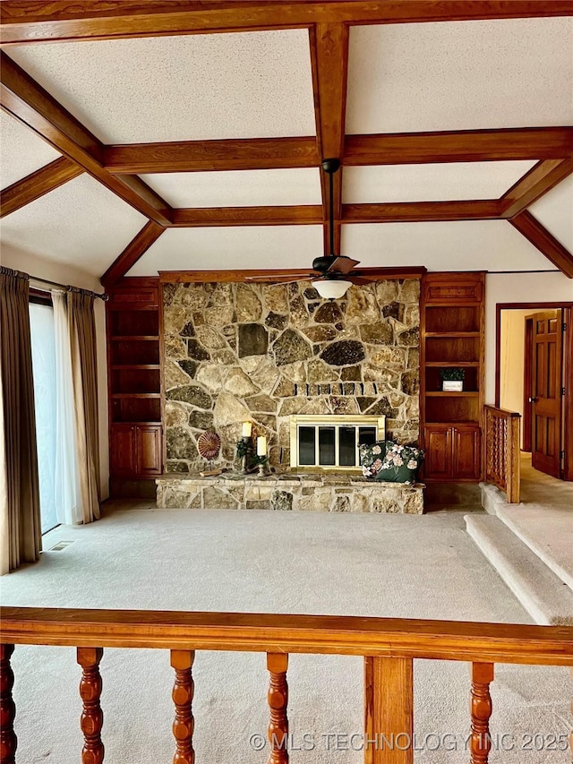 unfurnished living room with a textured ceiling, lofted ceiling with beams, carpet floors, built in features, and a fireplace