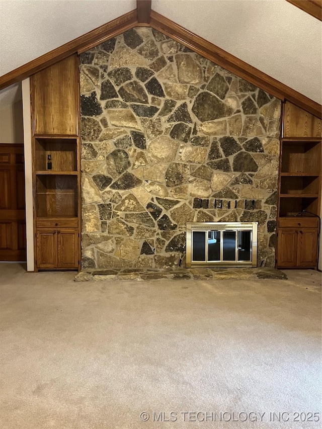 unfurnished living room featuring a stone fireplace, light carpet, and lofted ceiling with beams