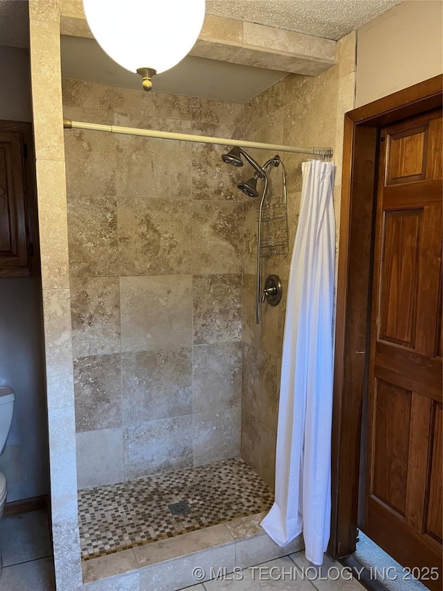 bathroom featuring a tile shower and toilet