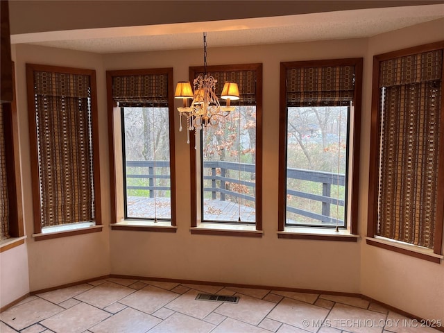 unfurnished dining area featuring an inviting chandelier, a healthy amount of sunlight, visible vents, and light tile patterned floors