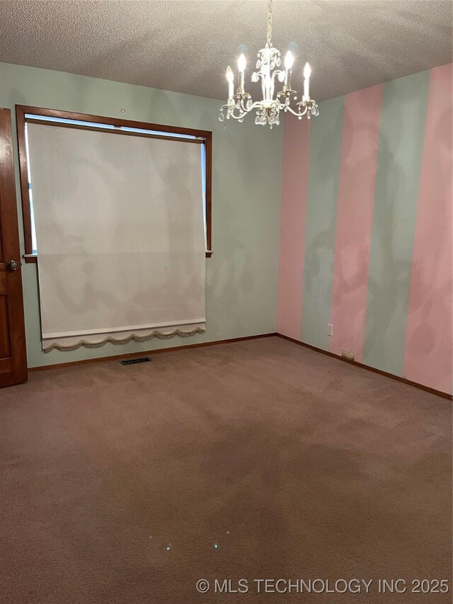unfurnished room with a textured ceiling, visible vents, carpet, and a chandelier