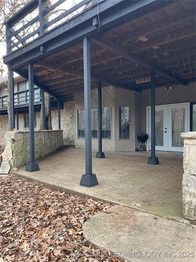 view of patio featuring a wooden deck, french doors, and grilling area