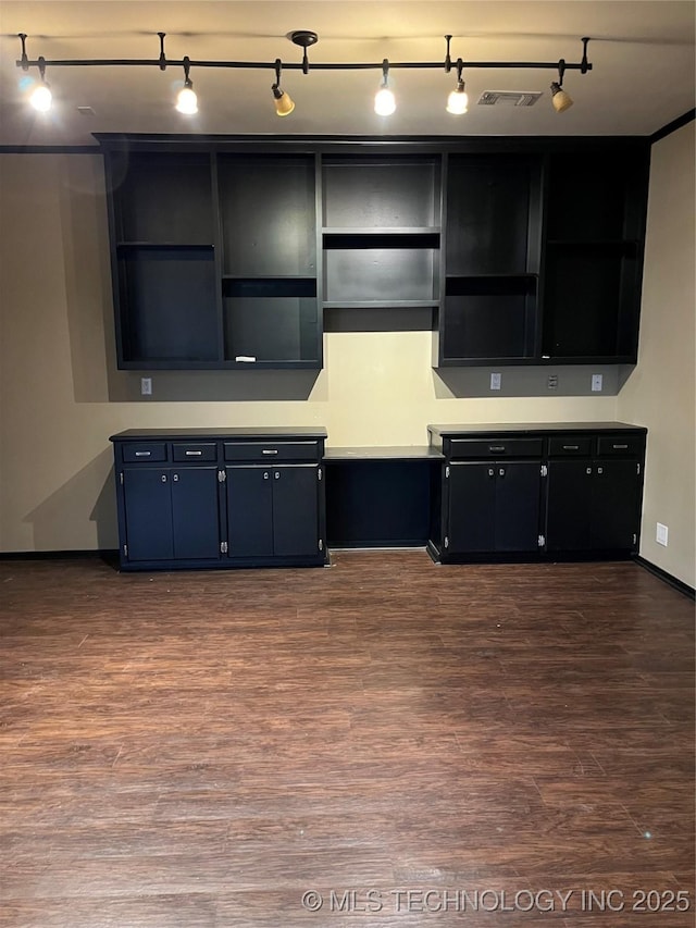 kitchen with open shelves, dark wood-type flooring, light countertops, and rail lighting