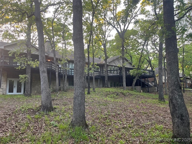 view of yard featuring a wooden deck, french doors, and stairs