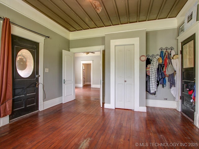 entrance foyer with ornamental molding, wooden ceiling, and dark wood-type flooring