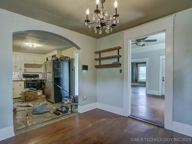 interior space featuring ceiling fan with notable chandelier and dark hardwood / wood-style floors