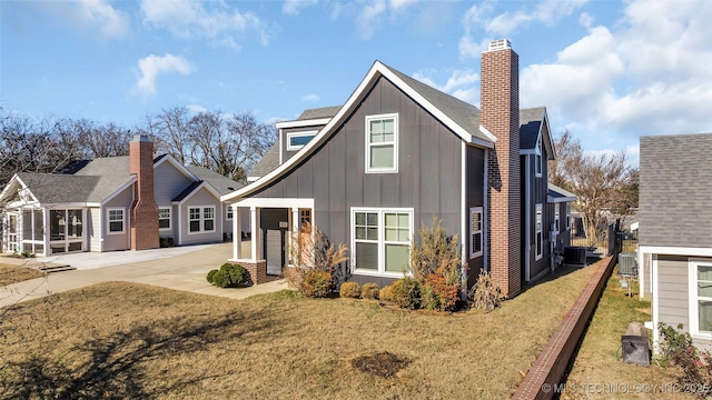 exterior space featuring cooling unit and a front yard