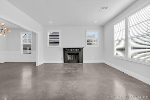 unfurnished living room featuring a chandelier