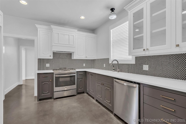 kitchen with white cabinetry, sink, stainless steel appliances, tasteful backsplash, and premium range hood