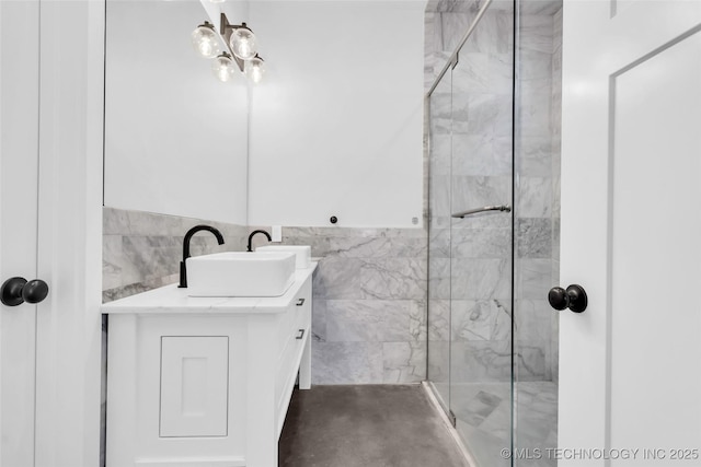 bathroom featuring vanity, a shower with door, and tile walls