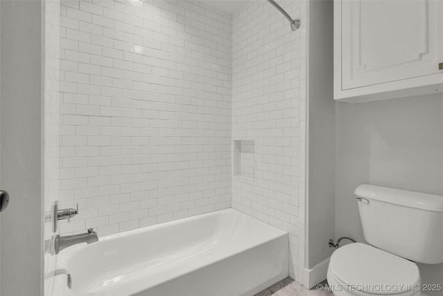 bathroom featuring toilet and tiled shower / bath