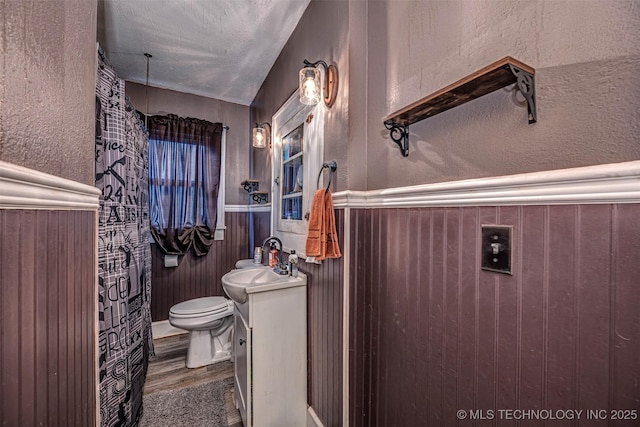 bathroom featuring a textured ceiling, vanity, toilet, and hardwood / wood-style floors