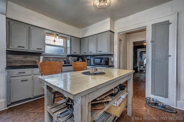 kitchen with decorative backsplash, dark parquet flooring, and gray cabinets