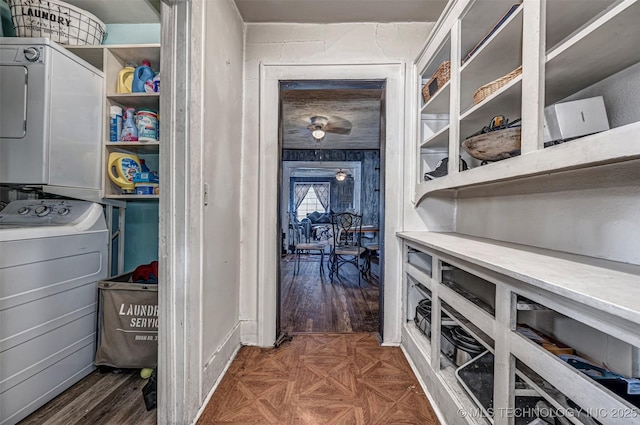 interior space featuring stacked washer / drying machine and dark parquet flooring