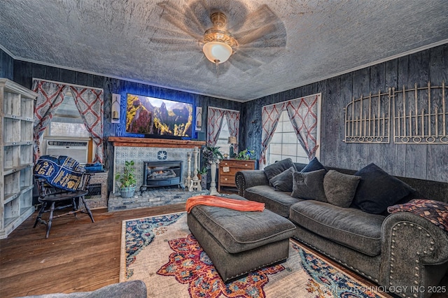 living room featuring hardwood / wood-style flooring, wood walls, a wood stove, and cooling unit