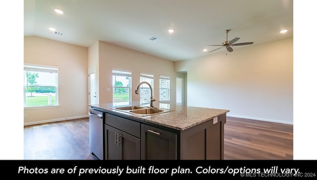 kitchen featuring light stone countertops, sink, dark wood-type flooring, stainless steel dishwasher, and a kitchen island with sink