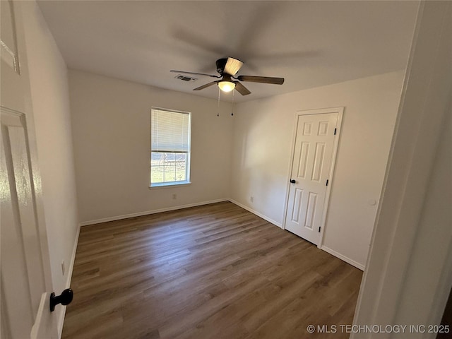 unfurnished room featuring ceiling fan and dark wood-type flooring