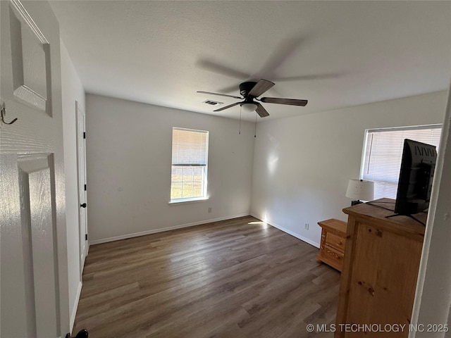 unfurnished living room featuring dark hardwood / wood-style flooring and ceiling fan