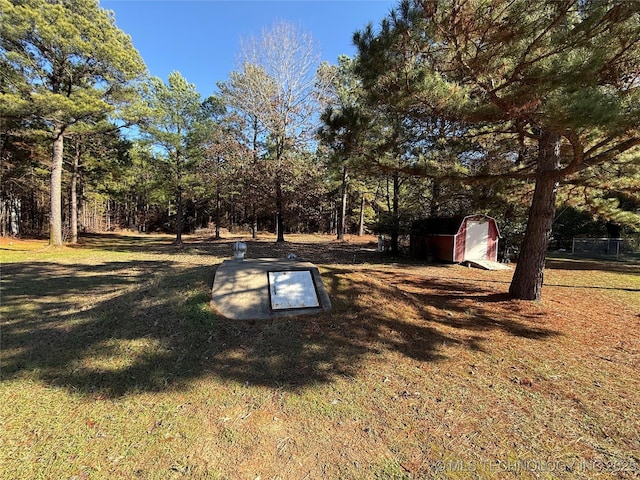 entry to storm shelter featuring a lawn and a shed