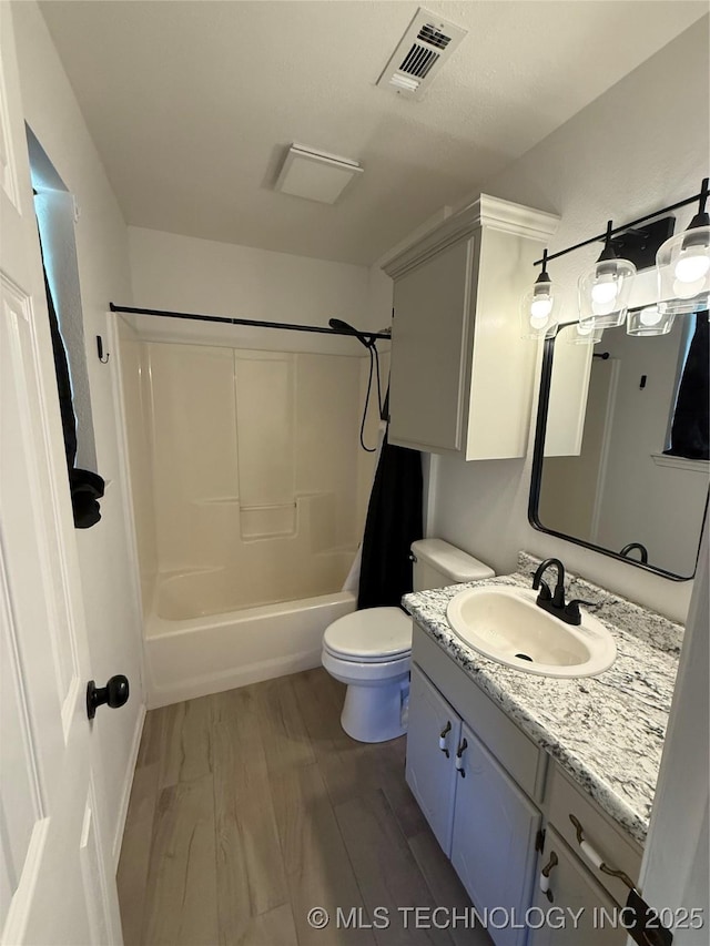 full bathroom featuring hardwood / wood-style flooring, vanity, toilet, and tub / shower combination