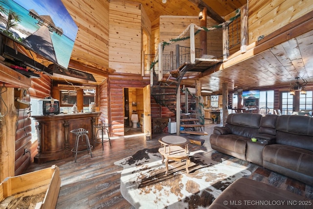 living room with wood walls, hardwood / wood-style floors, wood ceiling, and a high ceiling