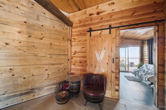 sitting room featuring hardwood / wood-style floors, lofted ceiling with beams, a barn door, log walls, and wood ceiling