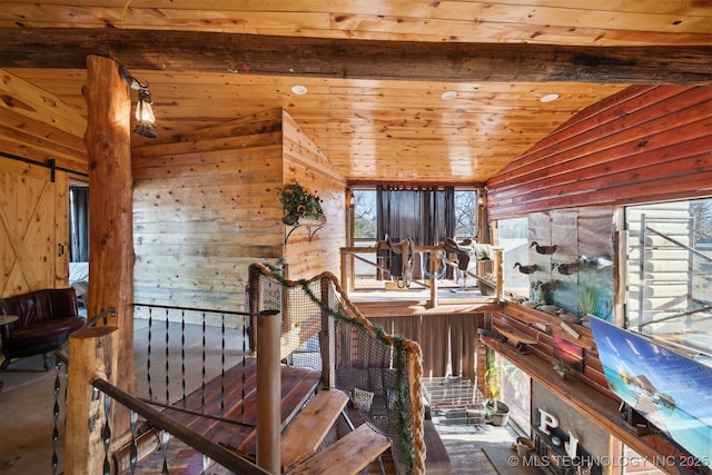 staircase with vaulted ceiling with beams, wood walls, and wooden ceiling