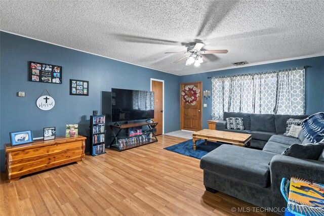 living room featuring ceiling fan, wood-type flooring, and a textured ceiling