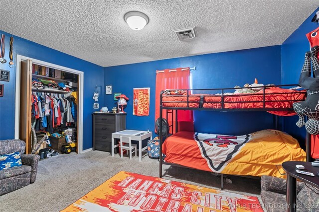 carpeted bedroom with a closet and a textured ceiling