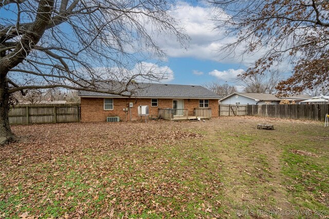 back of house with a deck and a lawn