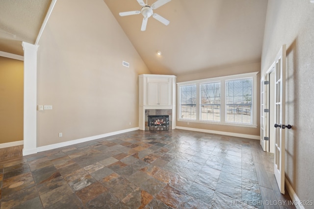 unfurnished living room featuring a tile fireplace, ceiling fan, and high vaulted ceiling