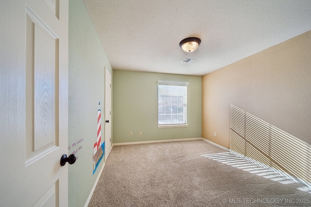 empty room featuring light carpet and a textured ceiling