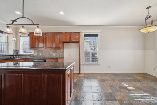 kitchen featuring stone tile floors, backsplash, ornamental molding, and a sink