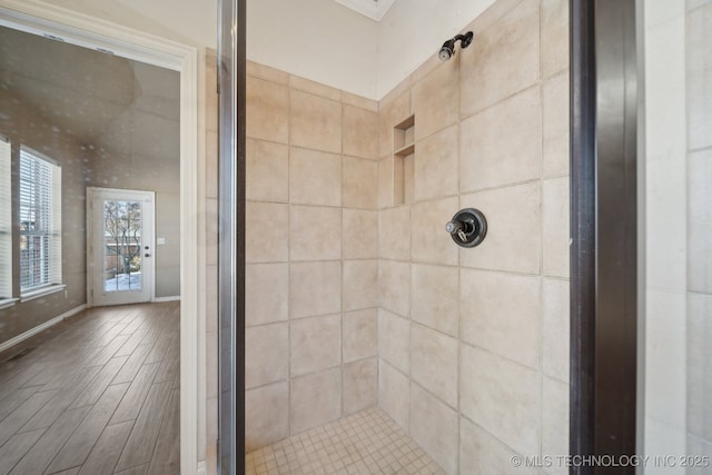 bathroom featuring a tile shower and hardwood / wood-style floors