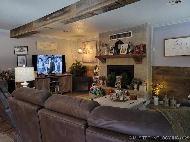 living room with crown molding, a fireplace, and a textured ceiling