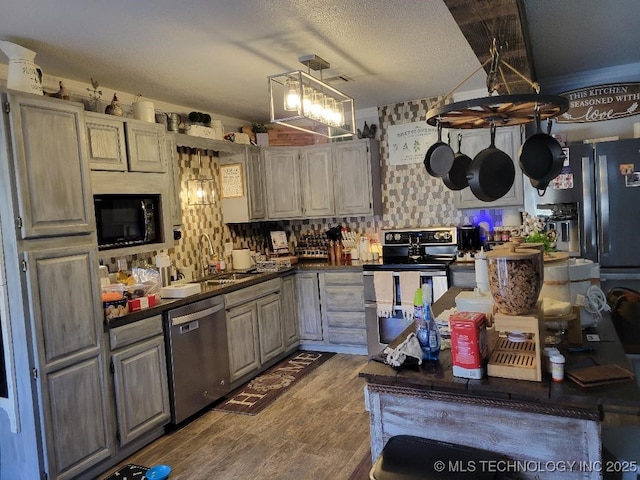 kitchen featuring dark hardwood / wood-style flooring, sink, black appliances, and a textured ceiling