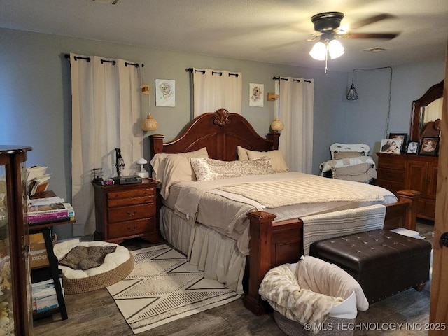 bedroom with ceiling fan and dark hardwood / wood-style flooring