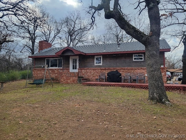 rear view of house with a yard and a deck