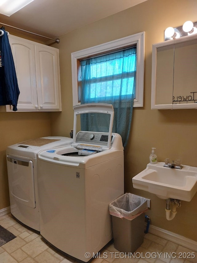 clothes washing area featuring cabinets, sink, washer and clothes dryer, and light tile patterned flooring